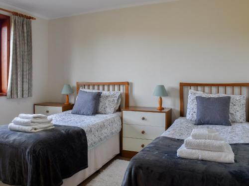 two beds in a bedroom with towels on them at Leys Barn in Great Chishall