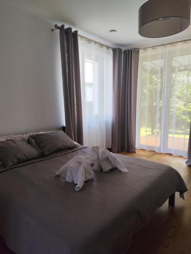 a bedroom with a large bed with a large window at Berryblossom Estate in Krosno