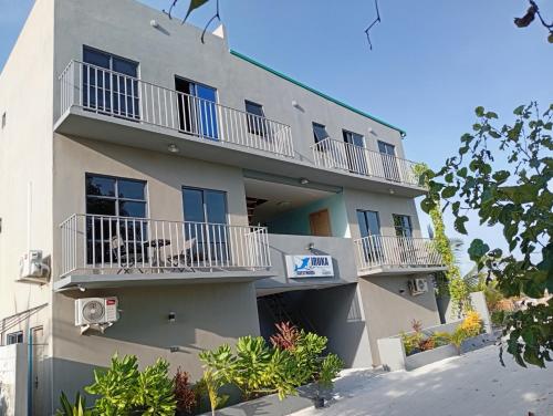 a building with balconies and a sign on it at iruka guesthouse in Bandara