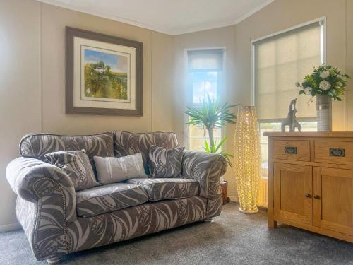 a living room with a leather couch and a window at Meadows Farm Lodge - Uk47614 in Gorseinon