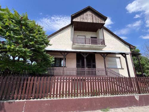 a house with a wooden fence in front of it at Babits Apartman in Tiszakécske