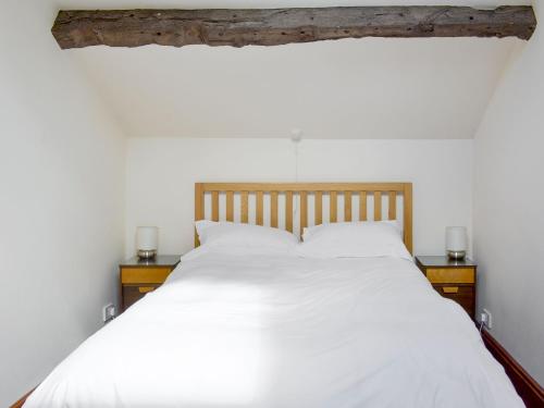 a bedroom with a white bed with two night stands at The Coach House in Corney
