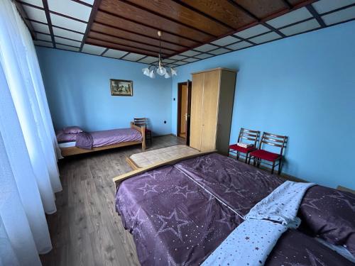 a bedroom with a bed with a purple comforter at Babits Apartman in Tiszakécske