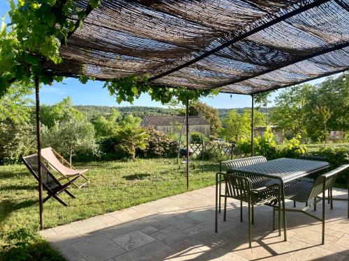 a patio with a table and chairs under a pergola at Chez Georges - Maison 3 - les Gîtes du Verdon in Esparron-de-Verdon