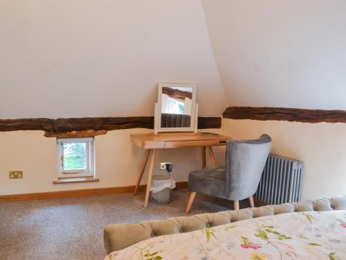 a bedroom with a desk and a chair and a bed at The Granary in Little Chart