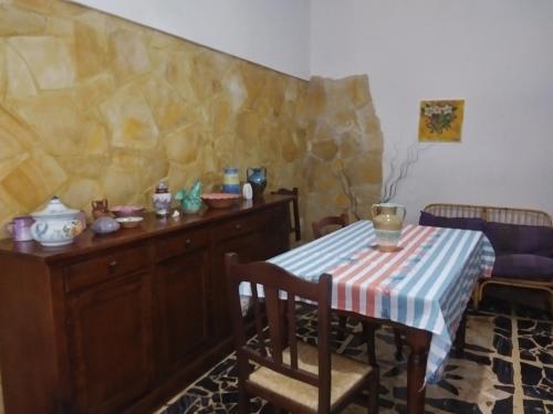 a dining room with a table and a table and chairs at Orchidea House in SantʼAntìoco