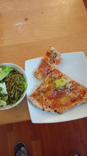 a plate with three slices of pizza and a bowl of salad at Vijay home in Jhunjhunūn