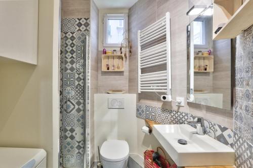 une salle de bain avec un lavabo blanc et des toilettes dans l'établissement Cosy et charmant appart 4 pers, à Paris