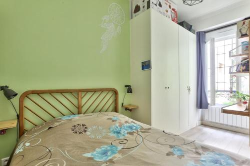 une chambre avec un lit dans une pièce avec une fenêtre dans l'établissement Cosy et charmant appart 4 pers, à Paris
