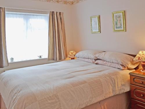 a bedroom with a bed and a window and a dresser at Abbotts Ball Farm in Potterne