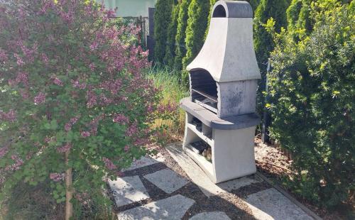 an outdoor oven sitting in the middle of a garden at Sea Suite Garden & Pines in Łukęcin