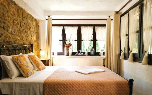 a bedroom with a bed in a room with windows at Ampelos Estate in Akrata