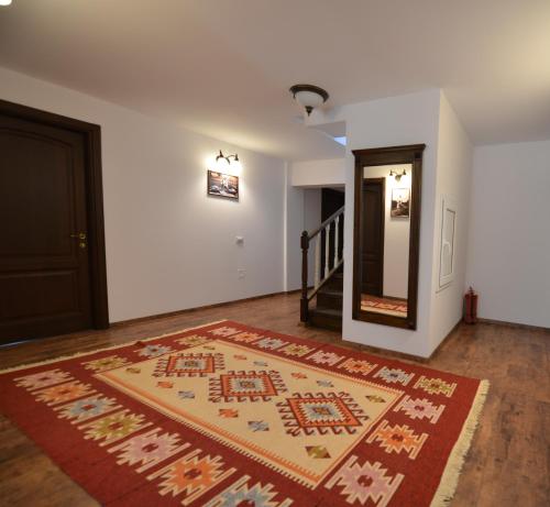 a hallway with a rug on the floor next to a door at Pensiunea Drumul Plutasilor in Alexandru cel Bun