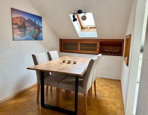 a dining room with a wooden table and chairs at Ferienwohnung am Staufen in Piding