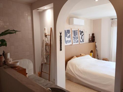 - une chambre avec un lit blanc et une douche dans l'établissement Villa des Oliviers le petit Versailles, à Castries