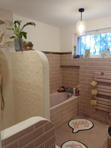 une salle de bain avec une baignoire et un lavabo dans l'établissement Villa des Oliviers le petit Versailles, à Castries