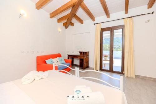 une chambre avec un lit, une chaise et une fenêtre dans l'établissement White Cottage, à Olbia