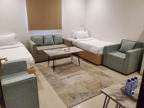 een kamer met 2 bedden, een bank en een tafel bij شقق مسكن ايار - Ayar Residence in Riyad