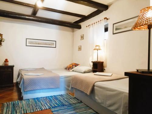a bedroom with two beds and a table and a lamp at Ampelos Estate in Akrata