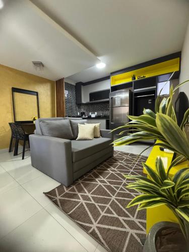 a living room with a couch and a kitchen at Casamar Lofts, Praia dos Anjos Arraial do Cabo in Arraial do Cabo
