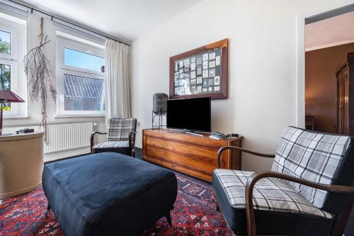 a living room with a bed and a tv and chairs at Landhaus Heiddorf in Neu Kaliß