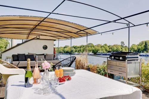 une table avec des assiettes et des bouteilles de vin sur un bateau dans l'établissement Parenthèse sur l eau Elegance à Saint-Cloud, à Saint-Cloud