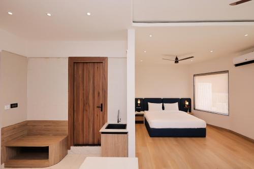 a bedroom with a bed and a wooden door at ECKO Tapovan by the Ganges in Rishīkesh