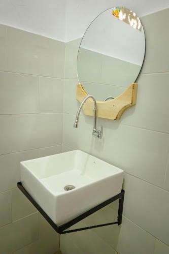 a bathroom with a white sink and a mirror at Mesari Cottage Guest House in Buleleng