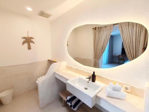 a bathroom with a sink and a mirror at Villa Chioni Uluwatu by LODGELINK BALI in Uluwatu