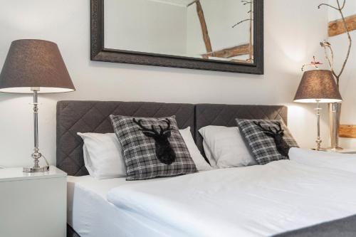 a bedroom with a bed with pillows and two lamps at Landhaus Heiddorf in Neu Kaliß