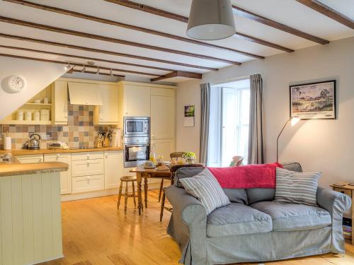 a living room with a couch and a kitchen at Dorothy Forster Court in Alnwick