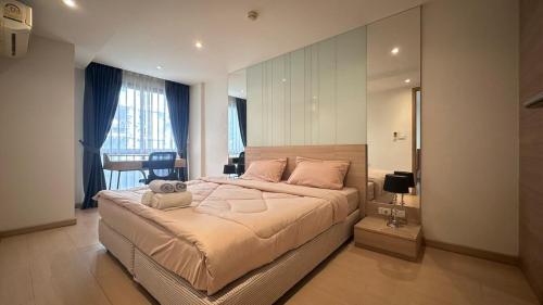a bedroom with a large bed with a large mirror at Wonderful condo BTS Ekkamai 7min by walking in Bangkok