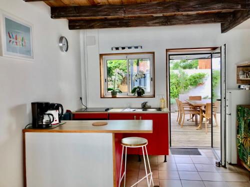 a kitchen with a red counter and a table at Charmante maison à Jard sur mer sur la côte vendéenne in Jard-sur-Mer