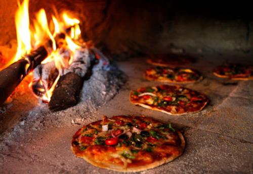 a group of pizzas are cooking in an oven at Saraya in Sangolda
