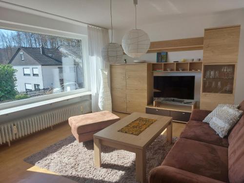 un soggiorno con un divano, un tavolo e una finestra di Ferienwohnung Josi a Heidenheim an der Brenz
