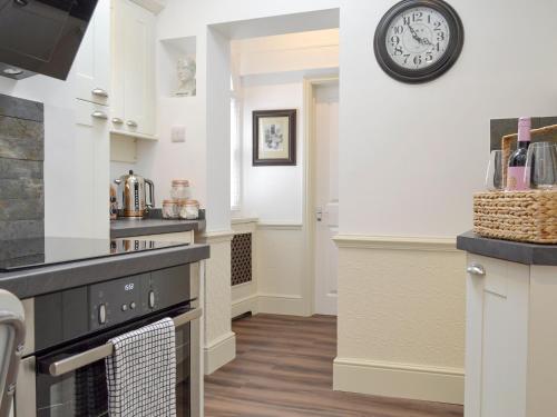 a kitchen with white walls and a clock on the wall at The Little House in York