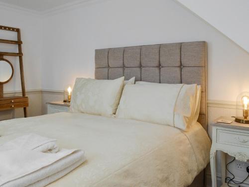 a bedroom with a large bed with white sheets and pillows at The Little House in York