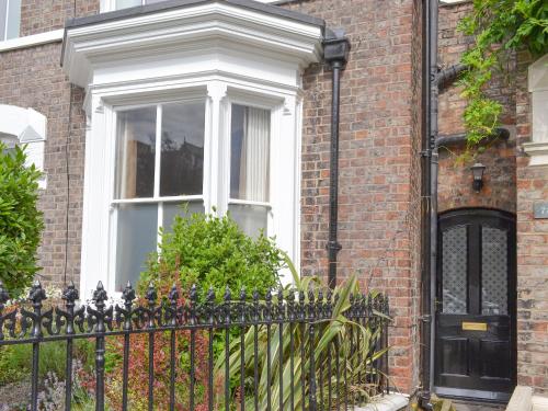a brick house with a black fence and a window at The Little House in York