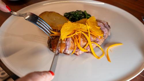 a plate with a piece of meat on a fork at Villa Balis Crema Verona Hills in Grezzana