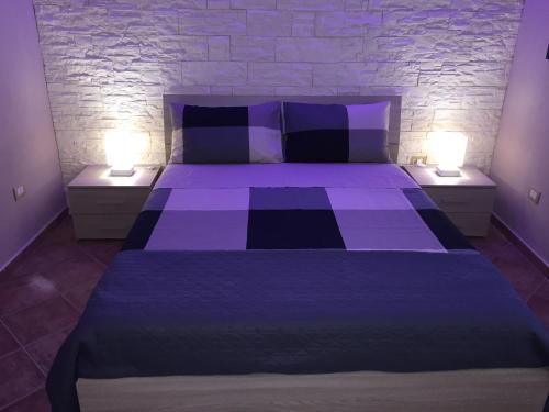 シラクーサにあるCalarossa residenceのベッドルーム(紫色のベッド、ランプ2つ付)