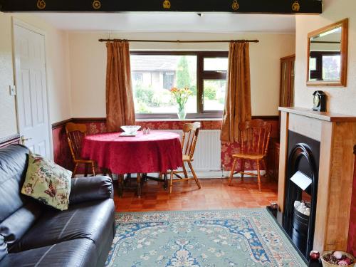 a living room with a table with a red table cloth at White Cottage in Hemingby