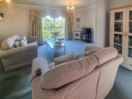 a living room with two couches and a television at Harwood Dale Cottage in Kendal