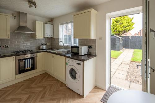 a kitchen with a washer and dryer in it at Falcon Cottage in Sleaford