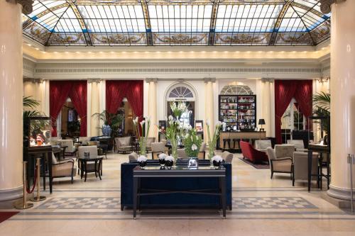 a lobby with tables and chairs in a building at Hotel Bellevue Palace Bern in Bern