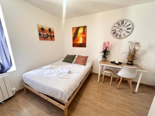 - une chambre avec un lit, un bureau et une horloge dans l'établissement Chavalliaud 12 cocon en RDC proche centre-ville, à Reims