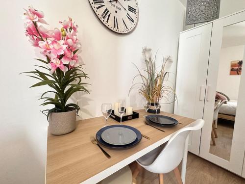 une table à manger avec une horloge sur le mur dans l'établissement Chavalliaud 12 cocon en RDC proche centre-ville, à Reims