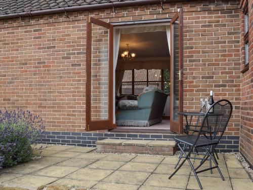 a black chair sitting in front of a brick house at Glossoms Lodge in Scalford
