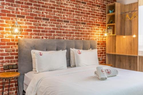 a bed with white pillows and a brick wall at W hotel in Dakhla