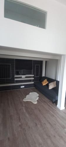 a living room with a blue couch and a tv at Maison au calme avec jardin et grande terrasse in Brest