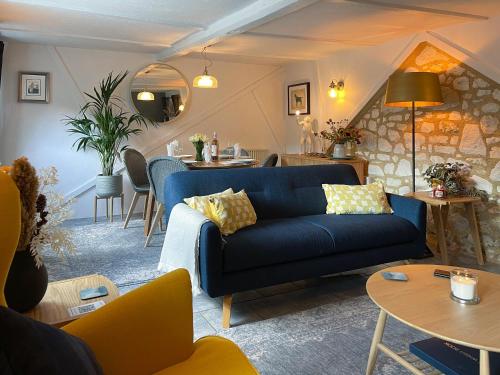 a living room with a blue couch and tables at Winkle Cottage in Calbourne